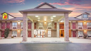 A hotel with a central entrance, multiple balconies, and a brick facade. - Super 8 by Wyndham Clinton (Clinton)