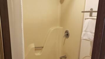 A bathroom with a bathtub, toilet, and shower.