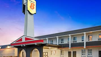 Un hôtel reconnaissable à son grand panneau « Super 8 », un bâtiment à deux étages et un parking.