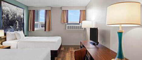 A hotel room with two beds, a desk, a chair, a lamp, a TV, and a window with curtains.