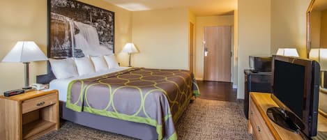 Une chambre d’hôtel avec un lit, deux lampes de chevet, une télévision, une table de chevet en bois, une commode et un grand tableau au mur.