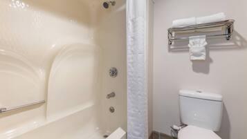 A bathroom with a bathtub, toilet, and a towel rack.