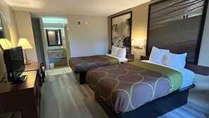 A hotel room with a large bed, a desk with a TV, and a bathroom visible through an open door. - Super 8 by Wyndham Fayetteville (Fayetteville)