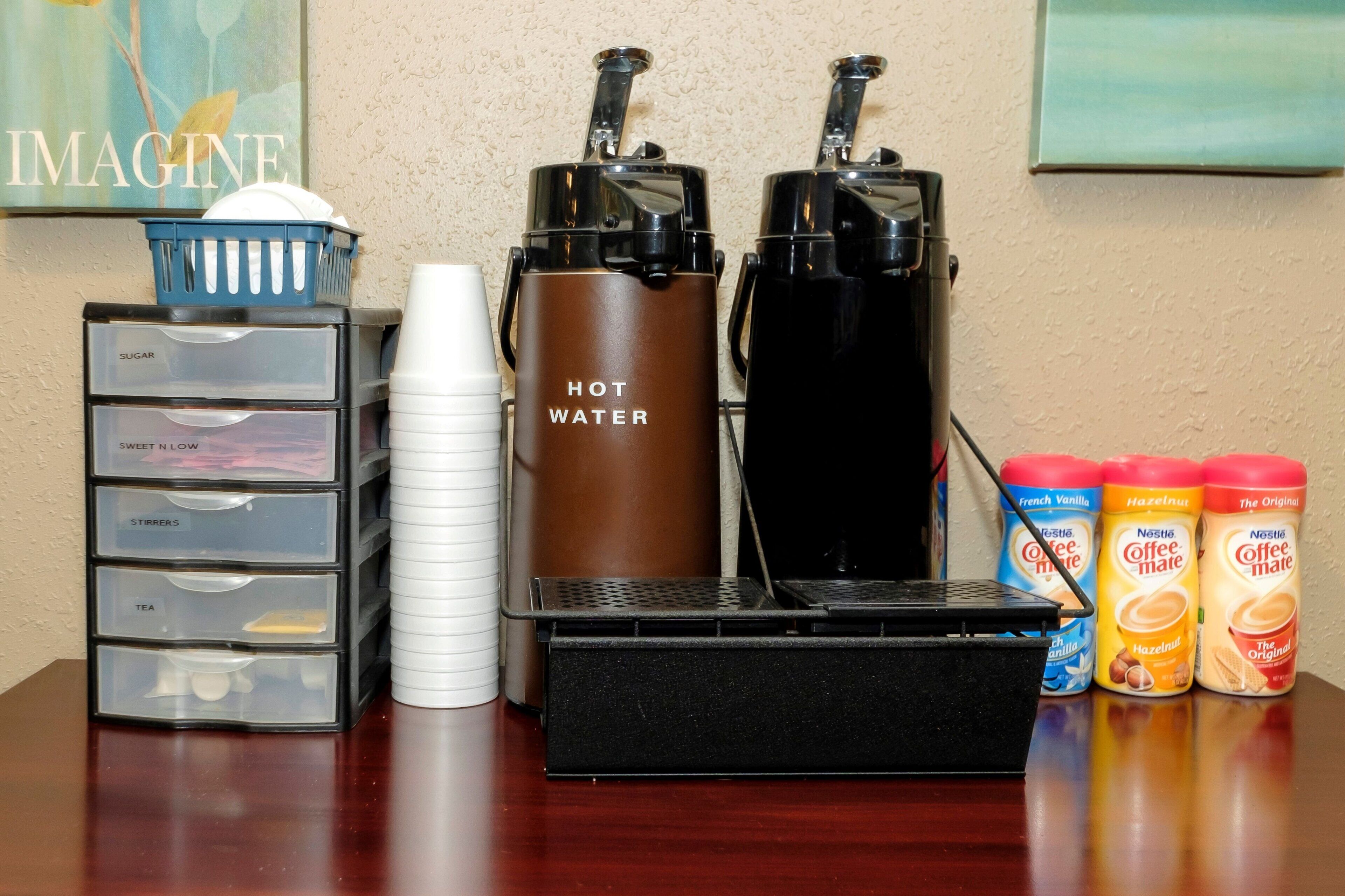 Una estación de café con dos cafeteras, un dispensador de agua y una máquina de café.