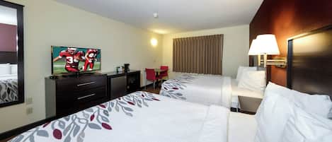 Une chambre d’hôtel avec deux lits, une télévision, un bureau, une chaise, une lampe et une fenêtre avec des rideaux.