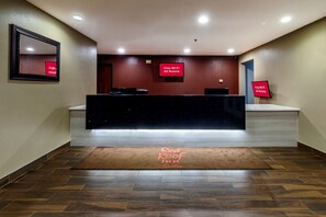 A hotel reception area with a desk, a sign indicating free Wi-Fi, and a starry night view on the wall.