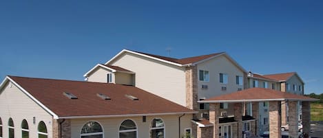 A multi-story residential building with a garage, large windows, and a brick facade.