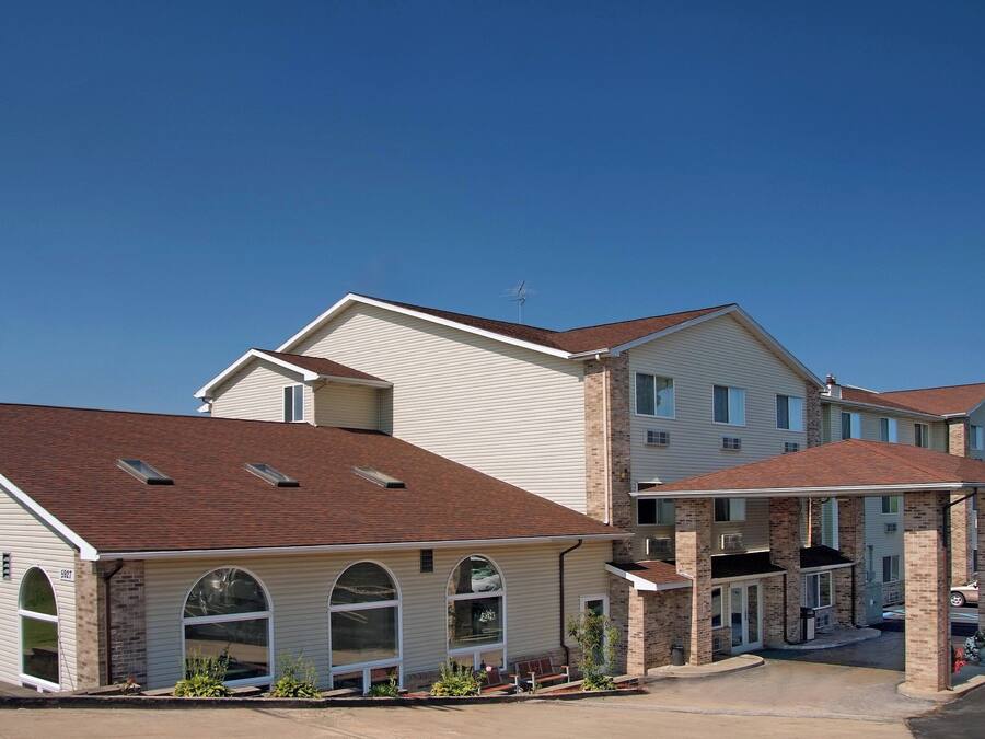A multi-story residential building with a garage, large windows, and a brick facade.