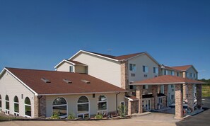 A multi-story residential building with a garage, large windows, and a brick facade.