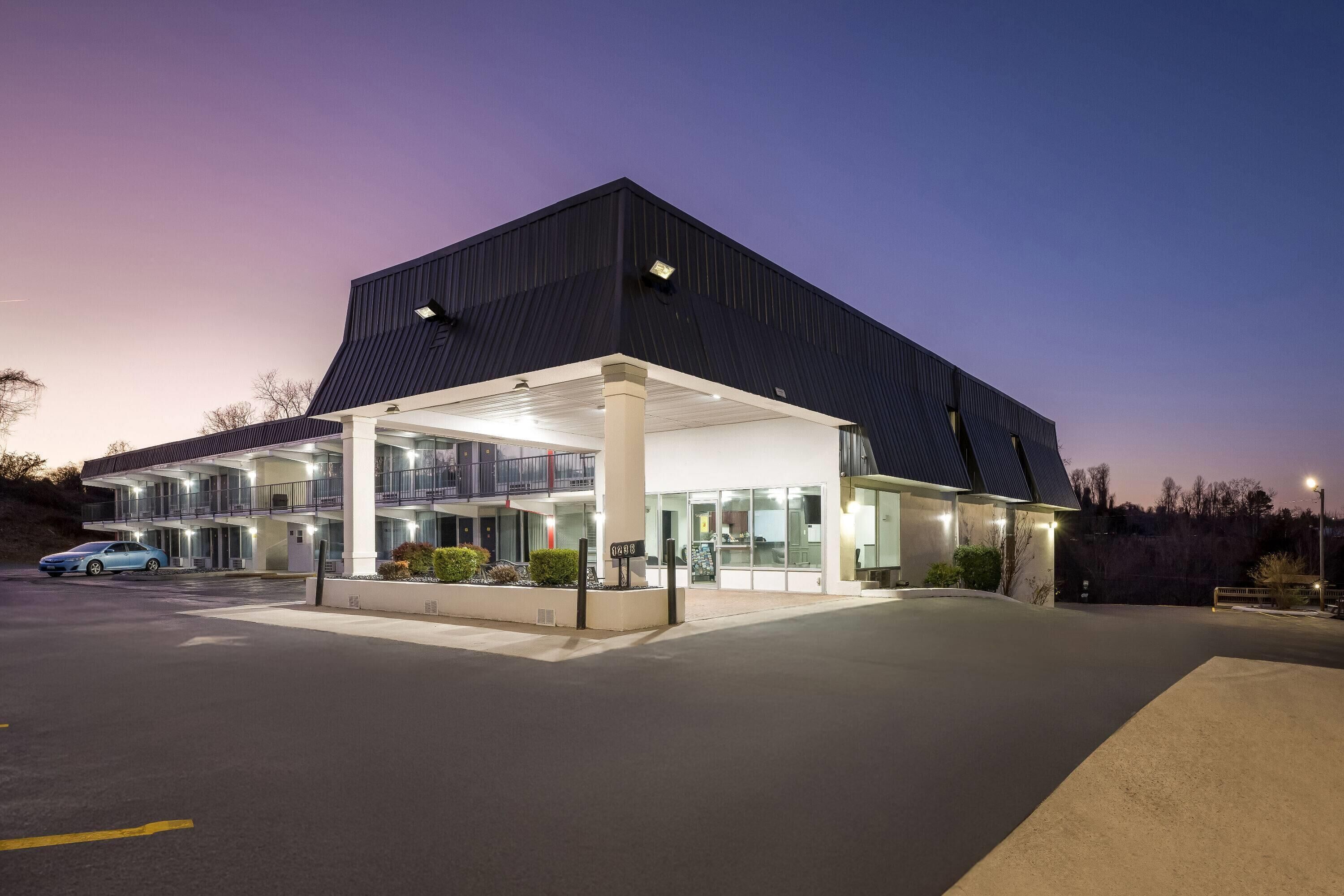 Un edificio moderno con parcheggio coperto, diversi piani e tetto piatto.