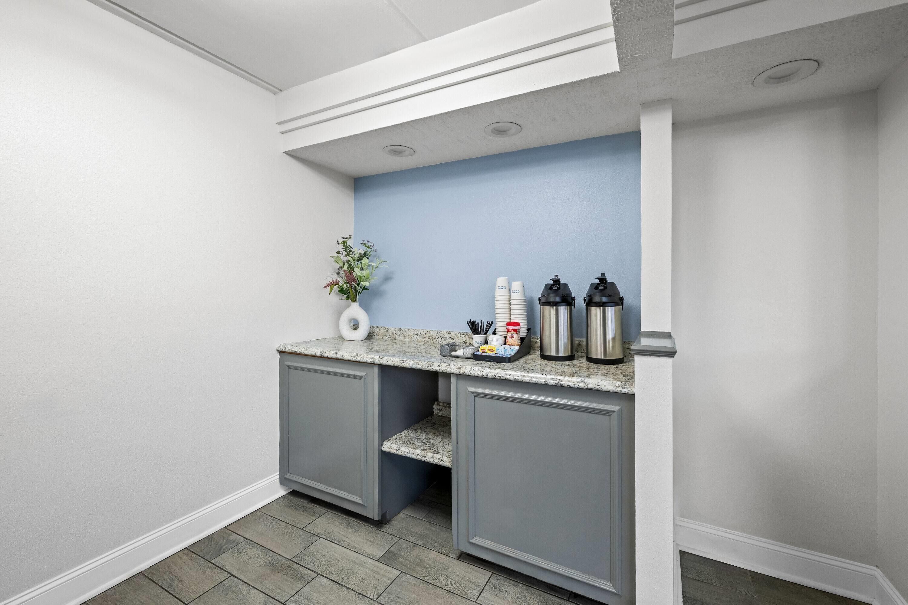 A kitchen area with a countertop, cabinets, and a blue wall.