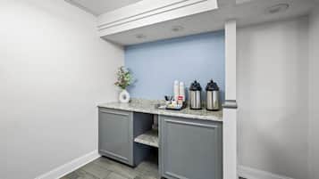 A kitchen area with a countertop, cabinets, and a blue wall.