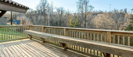 A wooden deck with a railing, a bench, and a Super 8 sign.
