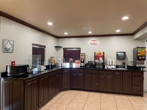 A breakfast area with a counter, microwave, coffee machine, and a sign for Superstart breakfast. - Super 8 by Wyndham Amarillo Central TX (Amarillo)