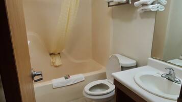 A bathroom with a bathtub, toilet, and sink.