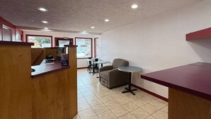 A clean, modern interior with a reception desk, seating area, and large windows. - Econo Lodge Galax (Galax)