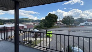 A view from a balcony overlooking a parking lot with a building in the background. - Econo Lodge Galax (Galax)