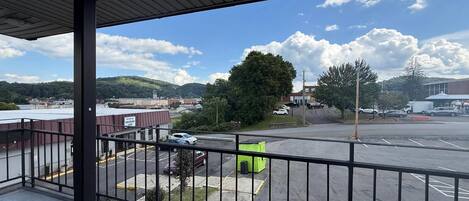 Vista da un balcone su un parcheggio, con un edificio sullo sfondo.