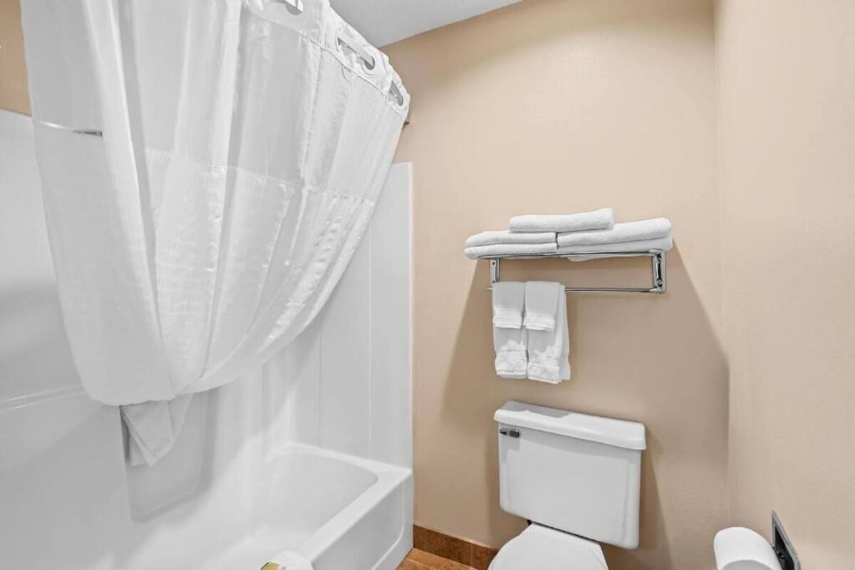 Un baño con bañera, inodoro y perchero para toallas.
