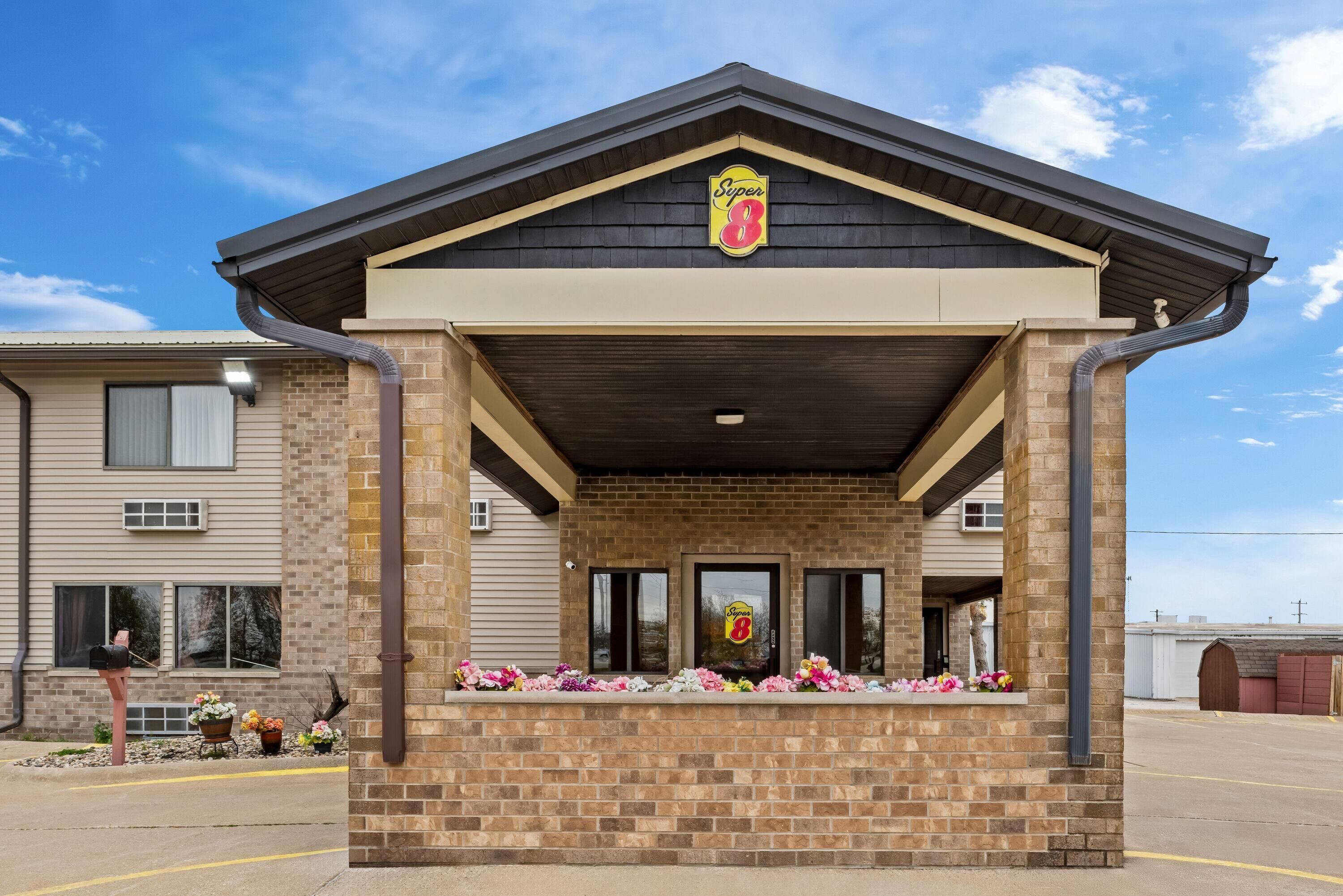 A Super 8 hotel with a brick facade, a dark roof, and a sign above the entrance.