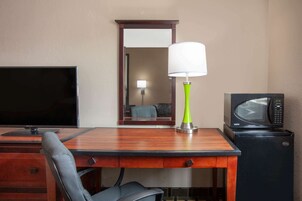 Escritorio, cortinas opacas, tabla de planchar con plancha