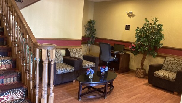 Eine Lobby mit Treppe, Sitzgelegenheiten und einer Rezeption.