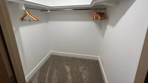 Ein Eckschrank mit weißer Decke, einem Holzbügel und einem Metallgestell.
