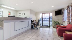 Un espace d’accueil comprenant un comptoir, un bureau, une chaise et un canapé.