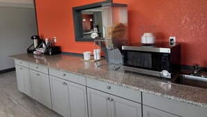 Eine moderne Küche mit Granitabdeckung, integriertem Mikrowellenherd und Spüle aus Edelstahl.