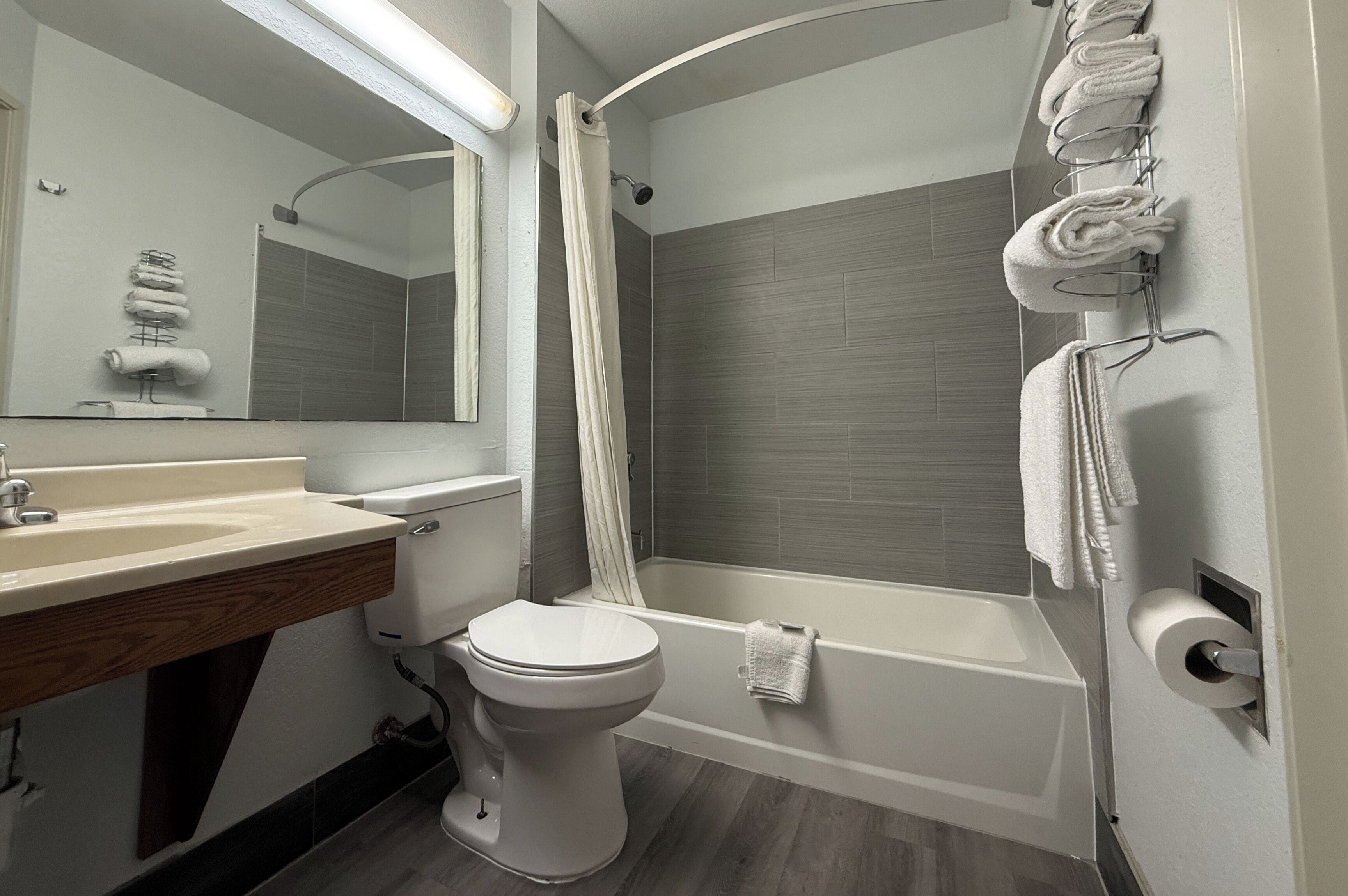 A modern bathroom with a toilet, sink, and bathtub.