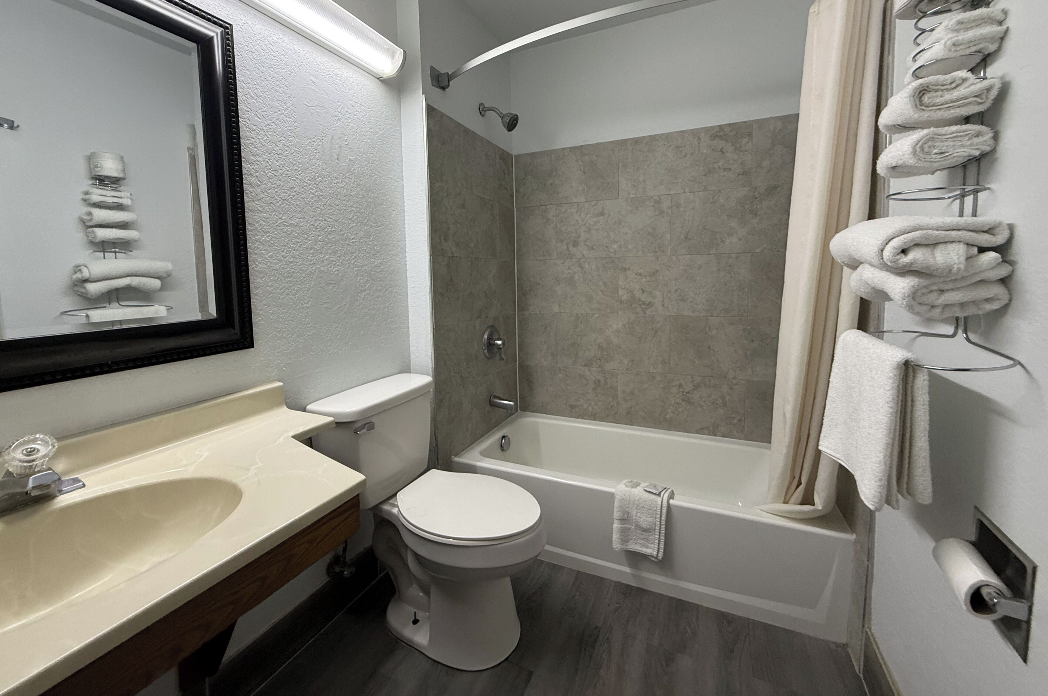 A bathroom with a sink, toilet, bathtub, and a towel rack.