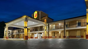 A hotel with a prominent 'Speed 8' sign, multiple balconies, and a spacious parking area. - Super 8 by Wyndham Pearl/Jackson Airport (Pearl)