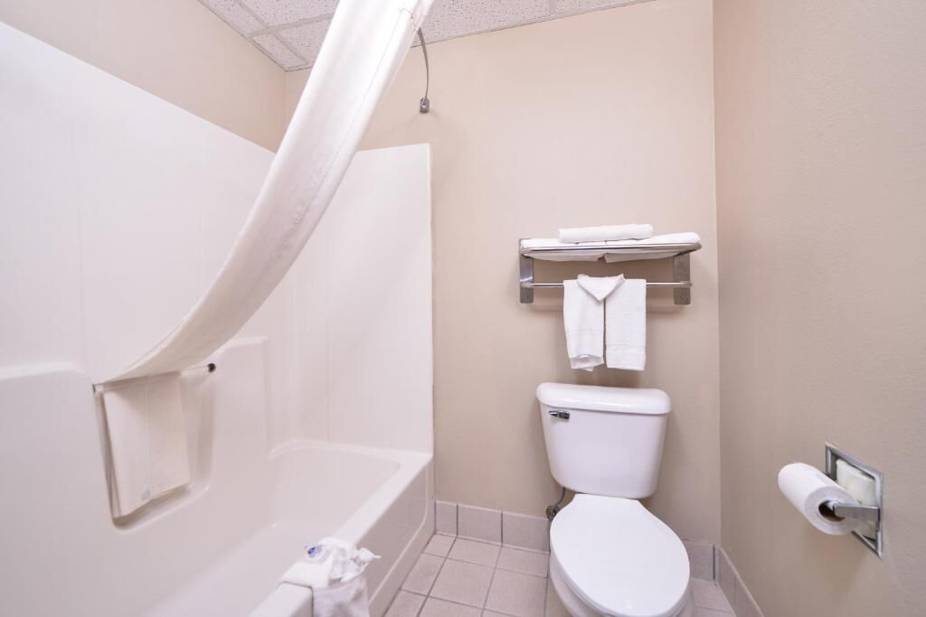 A bathroom with a bathtub, toilet, and towel rack.