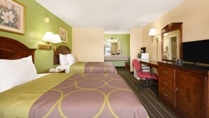 A hotel room with two beds, a desk, a chair, a dresser, and a television. - American INN of Orangeburg (Orangeburg)