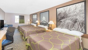 Quarto de hotel com duas camas, uma escrivaninha, uma cadeira e uma televisão.