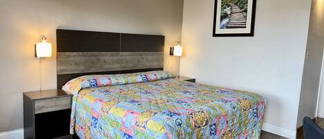 Un dormitorio con una cama grande, dos mesitas de noche y un cabecero.