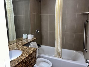 Kombinasi shower/bathtub, handuk, sabun, dan tisu toilet