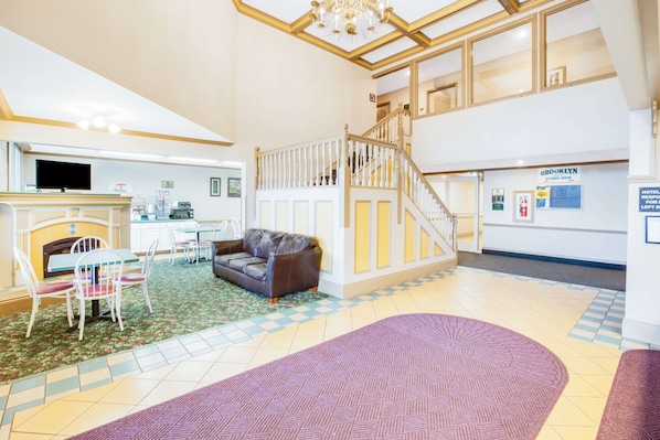 Un hall d’entrée spacieux avec une cheminée, un coin salon et un escalier menant à l’étage supérieur.