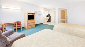 A hotel room with two beds, a desk with a chair, a television, a kitchenette, and a bathroom door. - Super 8 by Wyndham Brooklyn (Brooklyn)