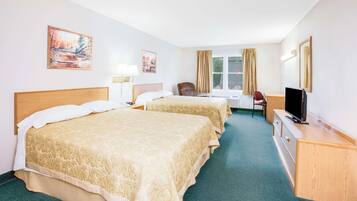 A hotel room with two beds, a desk, a chair, a TV, and artwork on the walls.