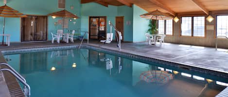 Una piscina techada, sillones reclinables de piscina