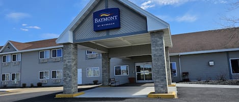 A hotel entrance with a sign reading "Baymont by Wyndham".
