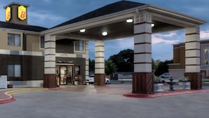 Un hôtel doté d’un espace extérieur couvert, de colonnes et d’une enseigne portant le chiffre 8.