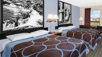 A hotel room with two beds, a large window, and artwork on the walls.