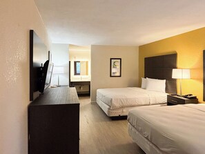 A hotel room with two beds, a desk, a TV, a bathroom, and a framed picture on the wall. - Motel 6 Charlotte, NC - Northlake (Charlotte)