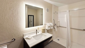 A bathroom with a sink, mirror, and shower. - Motel 6 Charlotte, NC - Northlake (Charlotte)