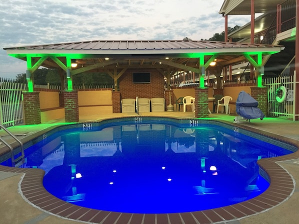 Una piscina al aire libre, sillones reclinables de piscina