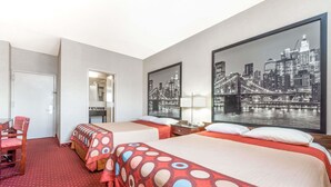 A hotel room with two beds, a desk, a chair, and a large cityscape painting on the wall. - Super 8 by Wyndham North Bergen NJ/NYC Area (North Bergen)