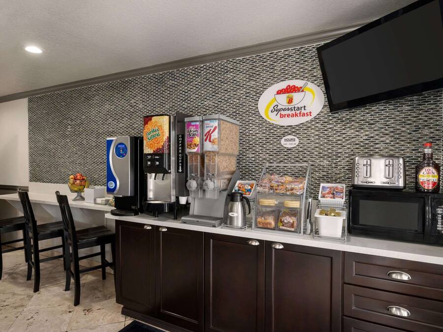 A breakfast bar with a coffee machine, cereal dispensers, and a microwave.
