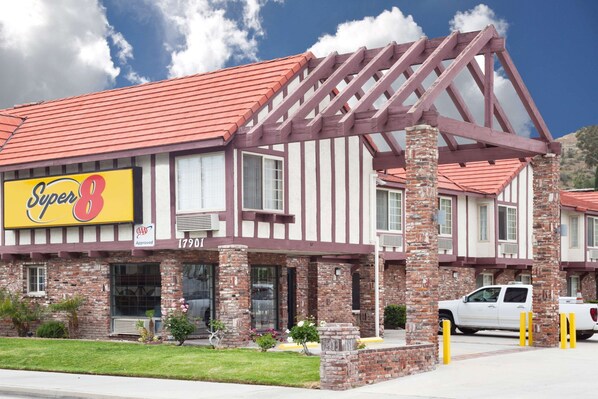 A Super 8 hotel with a red-tiled roof, brick facade, and a large sign. - Super 8 by Wyndham Santa Clarita/Valencia (Canyon Country)